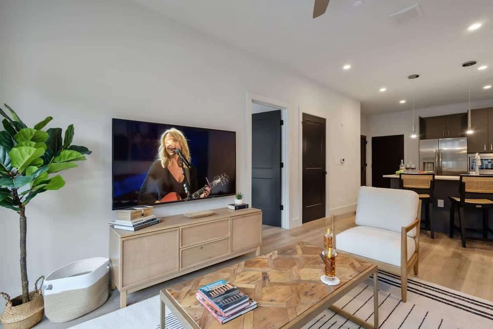 Bright living room with comfortable seating, a Smart TV, designer decor, and access to the outdoor patio.
