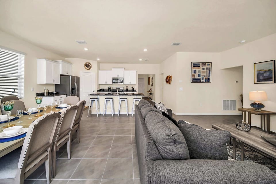 Experience comfort in this spacious open-plan living area with modern kitchen and ample seating, perfect for family gatherings.