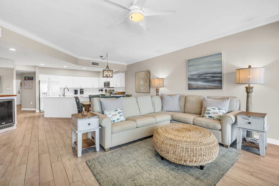 This well-appointed living space offers a comfortable sectional sofa, a round coffee table, and a dining area with seating for six, creating a welcoming atmosphere.