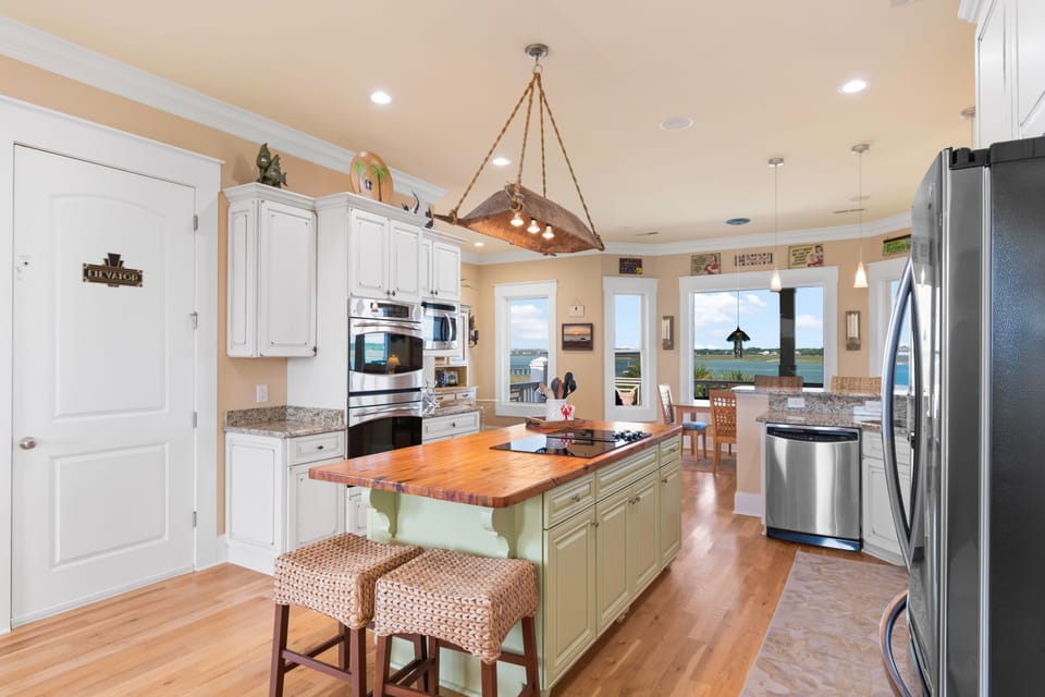 Your gourmet kitchen features granite counters, warm hardwood floors, and water views beyond—perfect for cooking memorable meals.