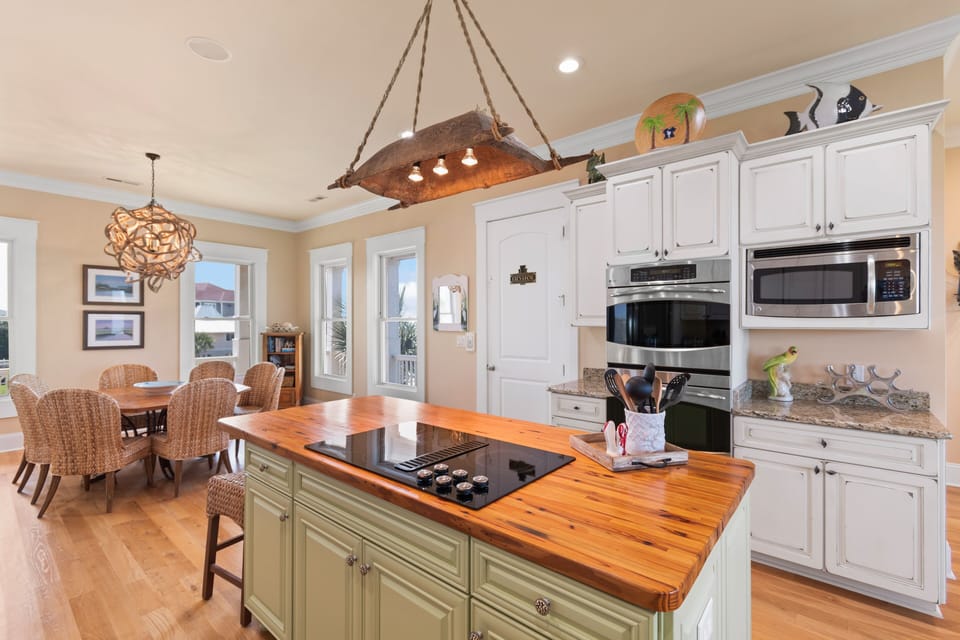 Your spacious kitchen features warm wood countertops, stainless steel appliances, and charming nautical touches that create the perfect space for cooking together.