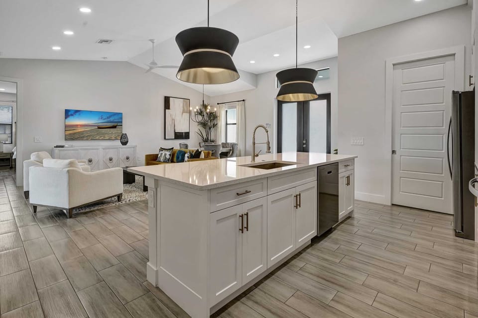 The kitchen island contains the sink, dishwasher and has seating for four