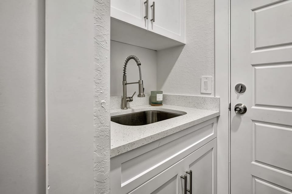 The laundry room includes a wash sink, the door leads to the garage