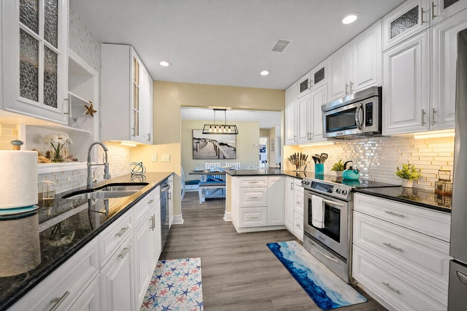 Moving through the open archway from the dining area, come on into the stunning kitchen with white cabinets and contrasting dark worktops creating an inviting space to cook up your best meals.
