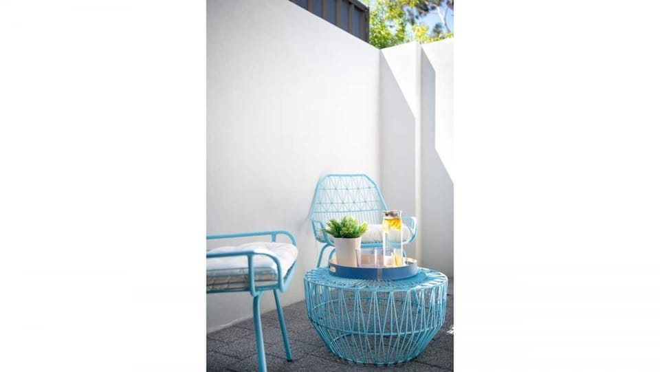 Peaceful outdoor spot with a side table and comfy chairs.