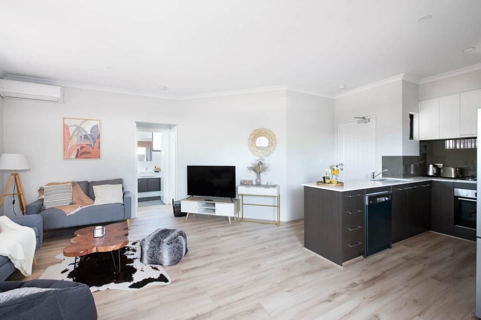 A bright and modern space thoughtfully designed for comfort, featuring a cosy sectional and entertainment setup.
