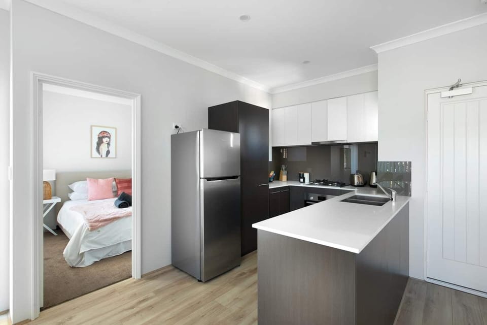 Contemporary kitchen featuring sleek cabinetry, full appliances, and a clean, modern design.