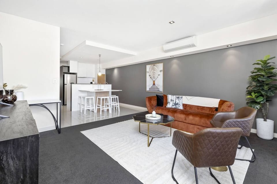 Contemporary living area with cozy seating and modern kitchen.
