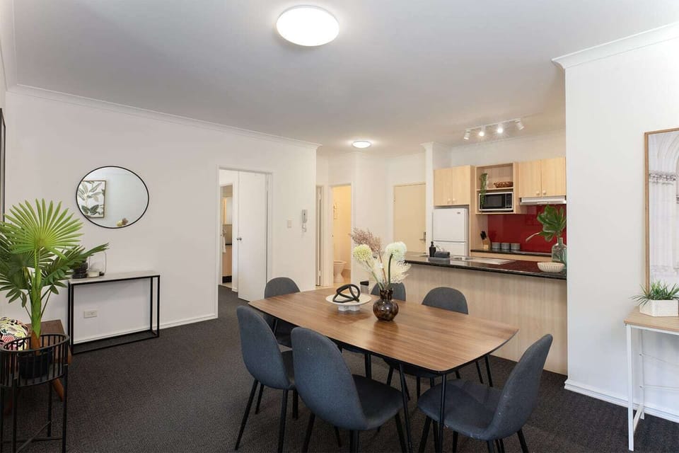 Functional layout showcasing the dining room, breakfast bar, and glimpse of the full kitchen.