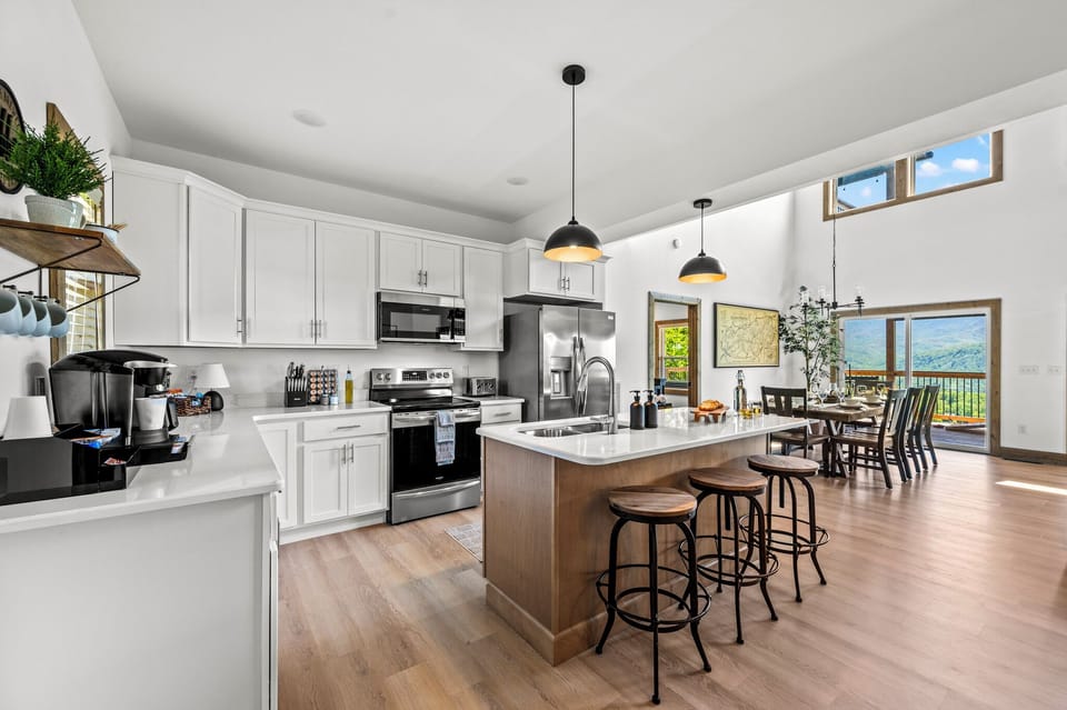 Fully Stocked Kitchen open to dinning room and extra setting at island