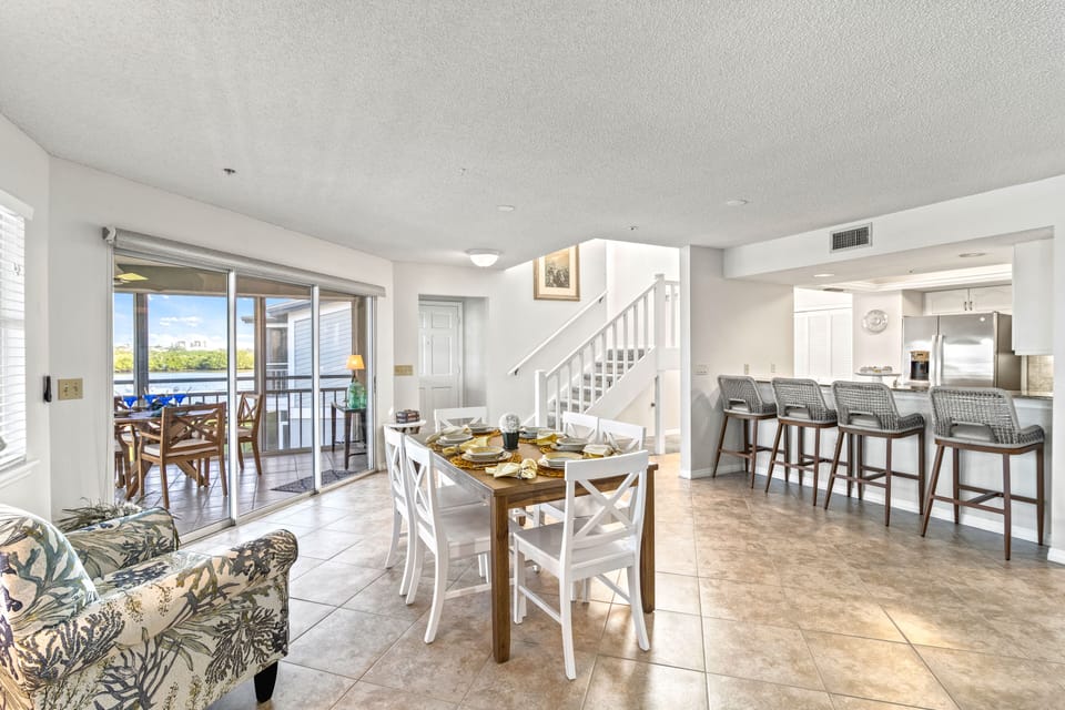 Dining area with waterfront view and kitchen breakfast bar.