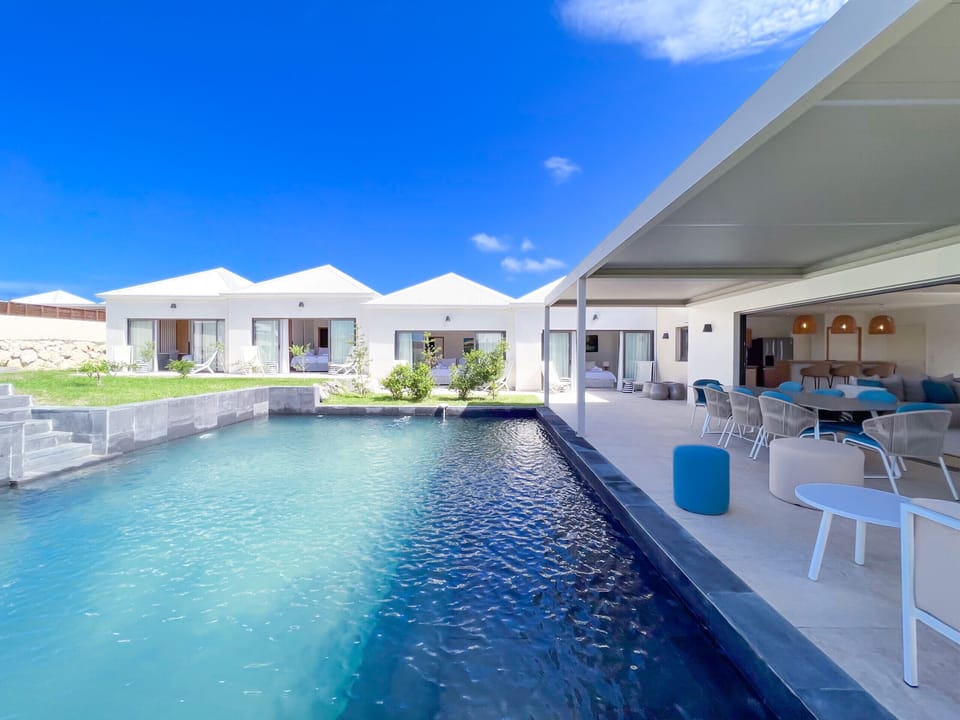 Image capturing a contemporary villa with an elegant pool and an open-plan lounge, furnished in a modern and minimalist style.