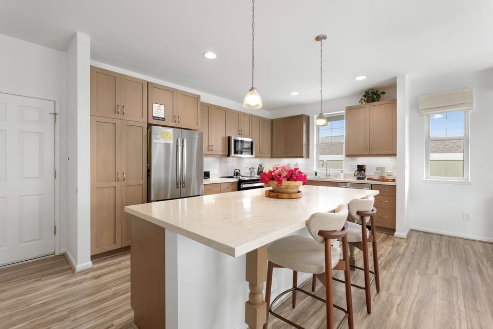 Fully equipped kitchen with modern appliances and barstool seating.