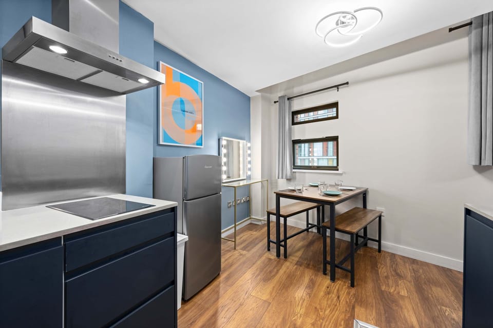 Fully equipped kitchen with stainless steel appliances, hob and extractor, plus a dining table by the window