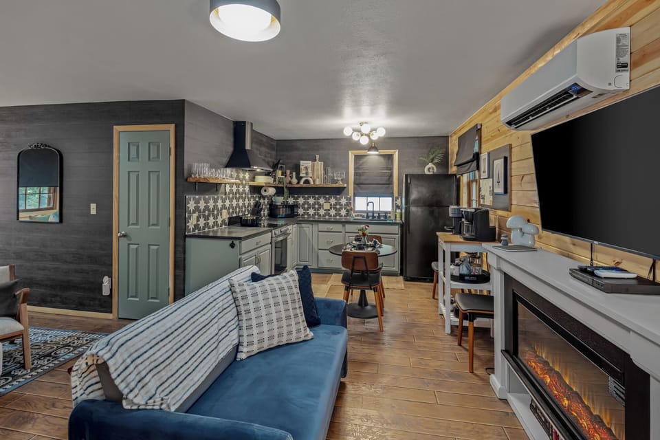 Stream your favorite shows on the large Smart TV while the electric fireplace creates a warm glow in this open-concept cabin. High-speed Starlink ensures you stay connected even while tucked away in this quiet woodland setting.
