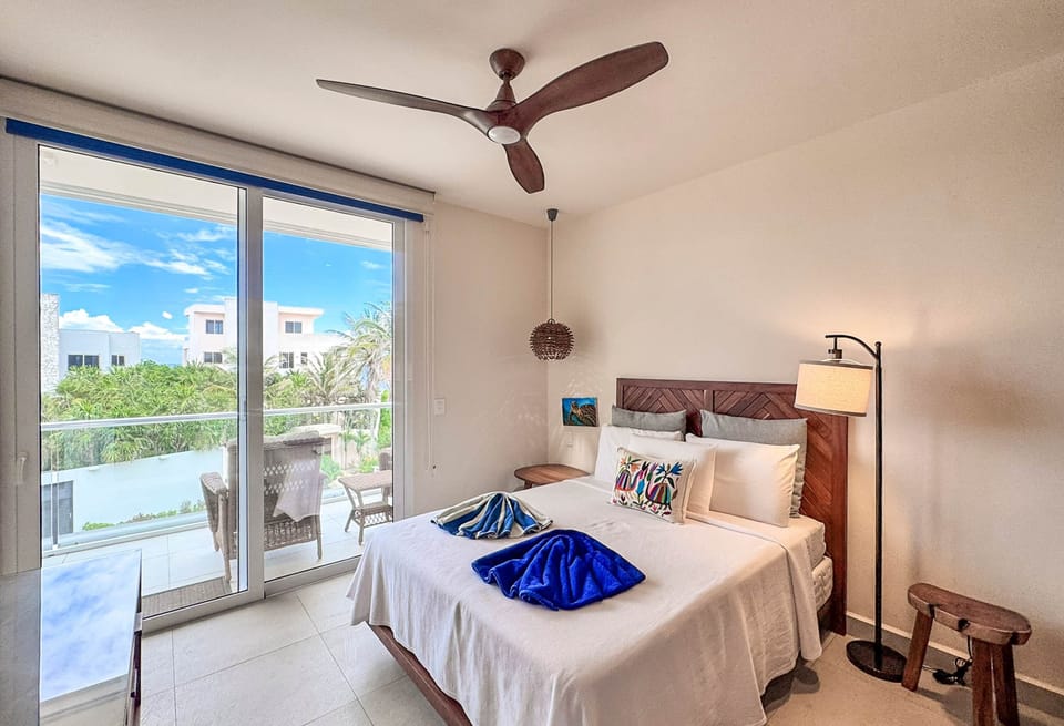 Cozy queen bed retreat with private balcony, ocean breeze, AC, and perfect sleep.
