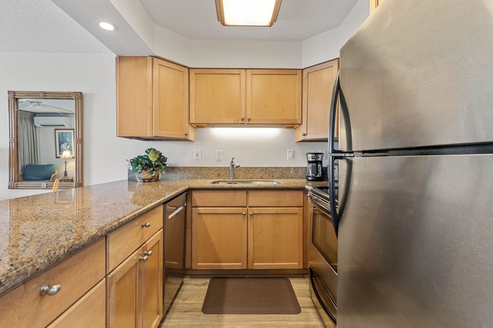 Fully stocked kitchen features granite countertops and stainless steel appliances