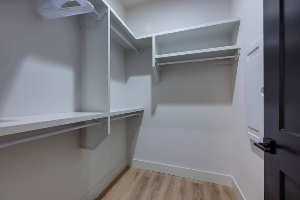 Primary Bedroom with king bed, smart TV, large walk-in closet, and en-suite bathroom.