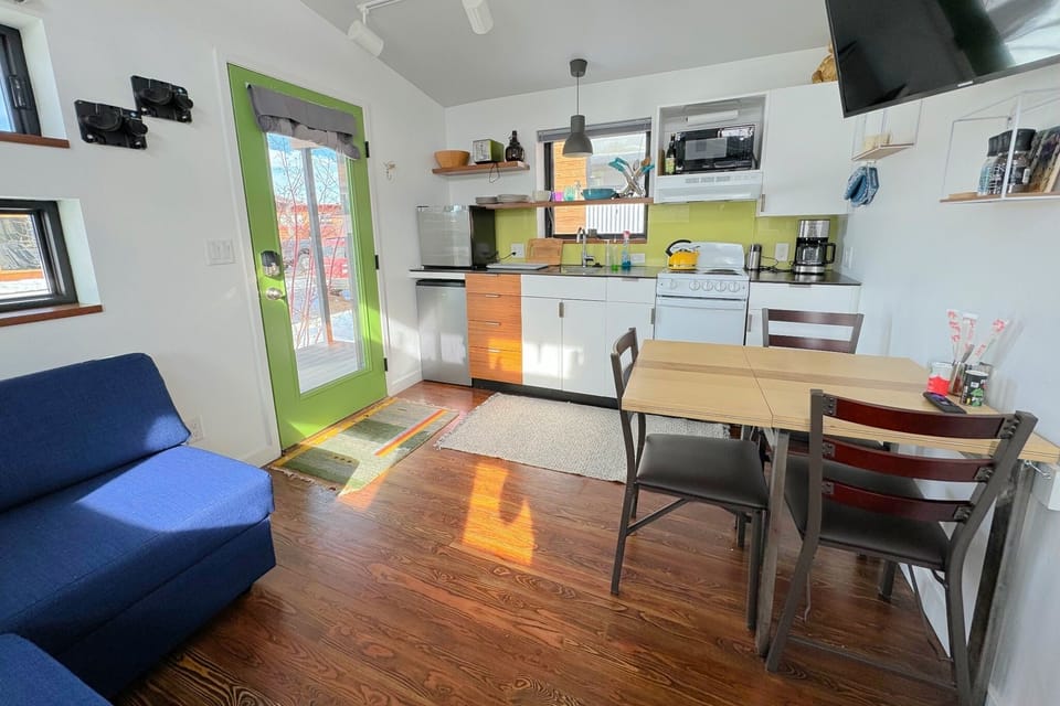 Living small does not mean going without — the comfortable living area, fully-equipped kitchen, and smart TV offer creature comforts not found in many other tiny homes.