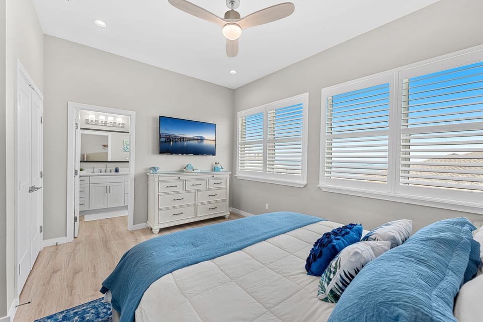 Spacious primary bedroom with a beautiful coastal vibe. Featuring a king-sized bed.