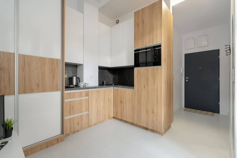 Another angle of the kitchen with built-in appliances and contrasting wood panels.
