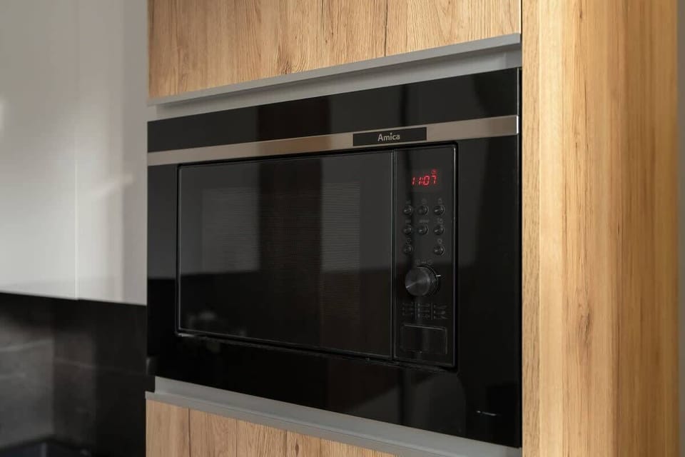 A close-up of the built-in microwave or oven, finished in glossy black.
