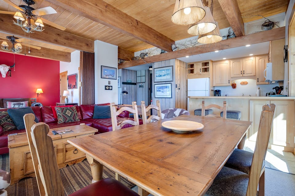 Gather around this rustic dining table where your mountain meals become memorable moments, surrounded by warm wood beams and cozy lodge charm.