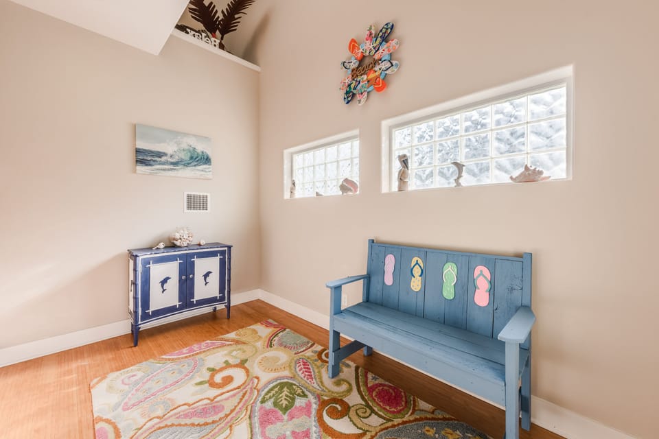 Discover your coastal-themed corner with charming flip-flop bench seating, ocean artwork, and decorative shells creating the perfect beachy welcome space.