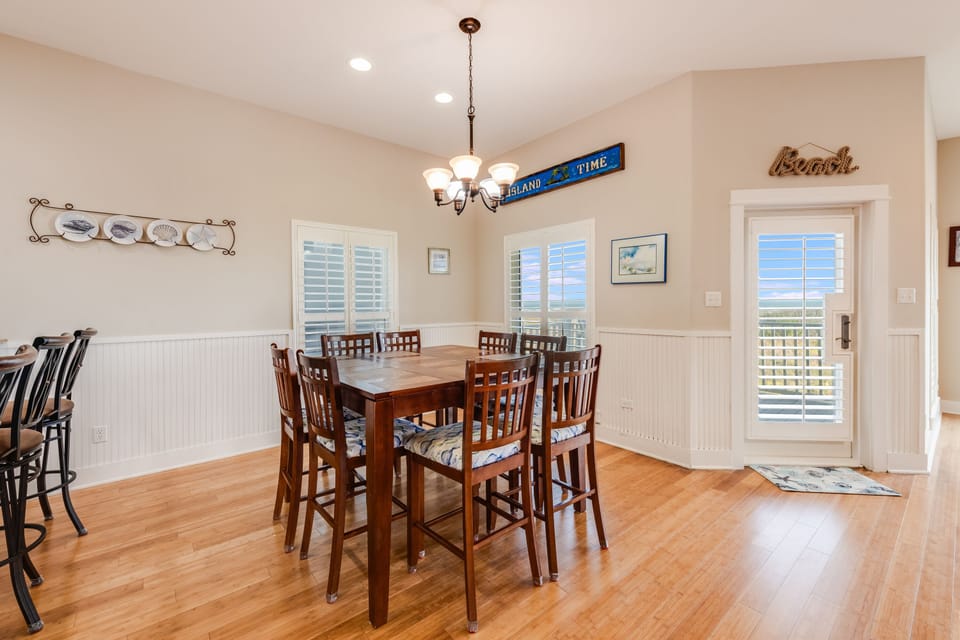 Gather around the spacious dining table where family meals become cherished memories, with coastal charm and natural light flowing through plantation shutters.