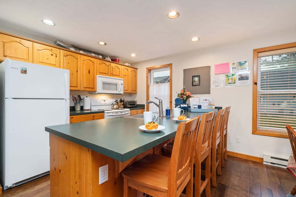 Fully equipped kitchen with breakfast bar, open to living room and dining room .