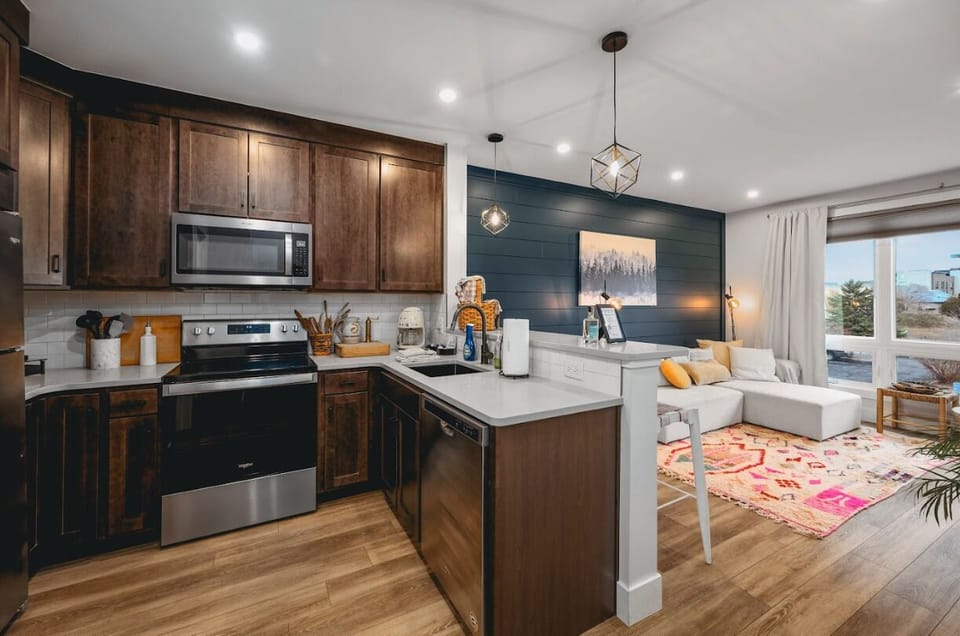 Open-concept kitchen w/ rich wood cabinets, white counters & seamless flow to the living area.