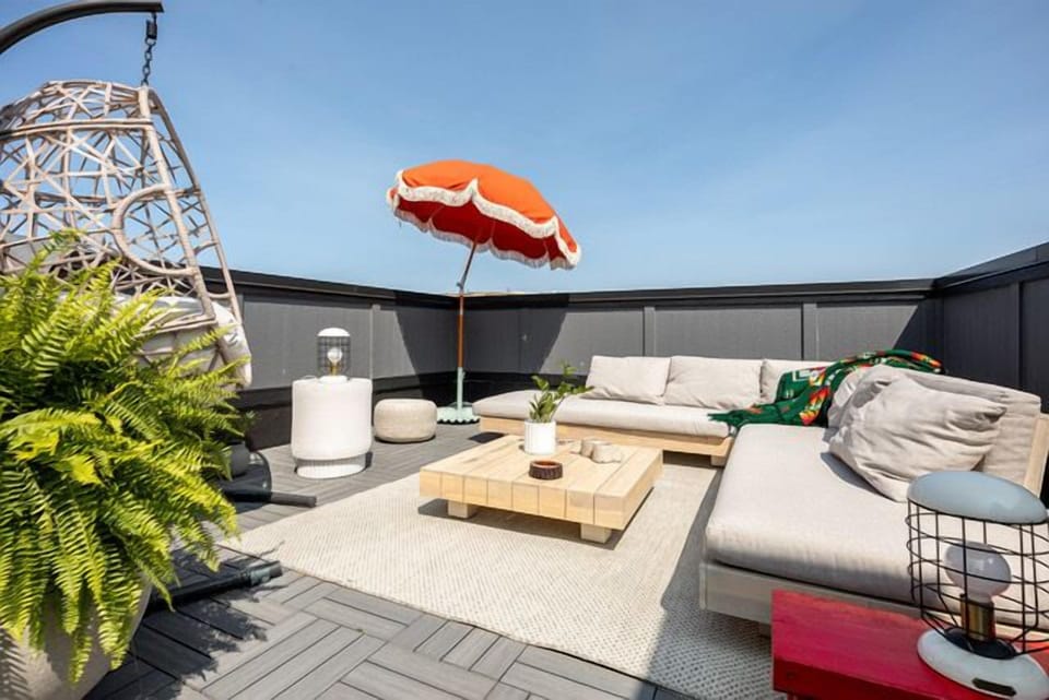 Spacious rooftop deck w/ comfy seating, umbrella & room to unwind in the sun.