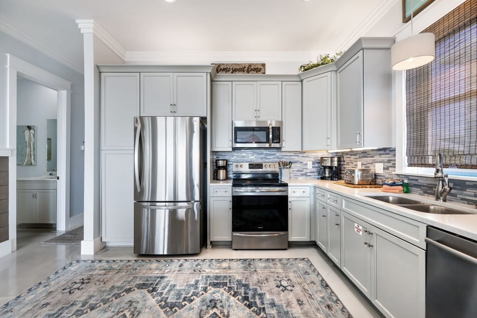 Your fully equipped kitchen features stainless steel appliances and crisp white cabinets, perfect for preparing meals at home.