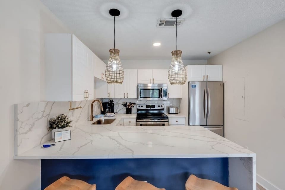 - Cook up memories in a sleek kitchen with shiny stainless steel and marble style counters - Grab a stool, pour a drink, and vibe under those glowing woven lights - Whether it’s breakfast or late night snacks, this spot’s got you covered