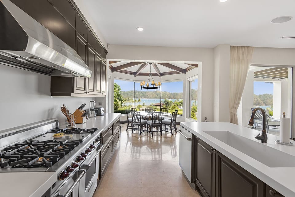 Culinary aspirations come to life in the gourmet kitchen, adorned with high-end appliances, sleek countertops, and ample space for the culinary enthusiast. The panoramic ocean views provide a breathtaking backdrop to every meal.