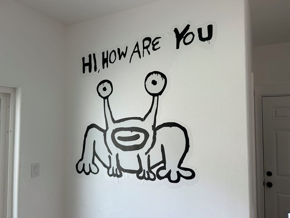 This photo showcases a mural inspired by the iconic "Hi, How Are You?" artwork by Daniel Johnston, a beloved figure in Austin's music and art scene. The original mural on Guadalupe St