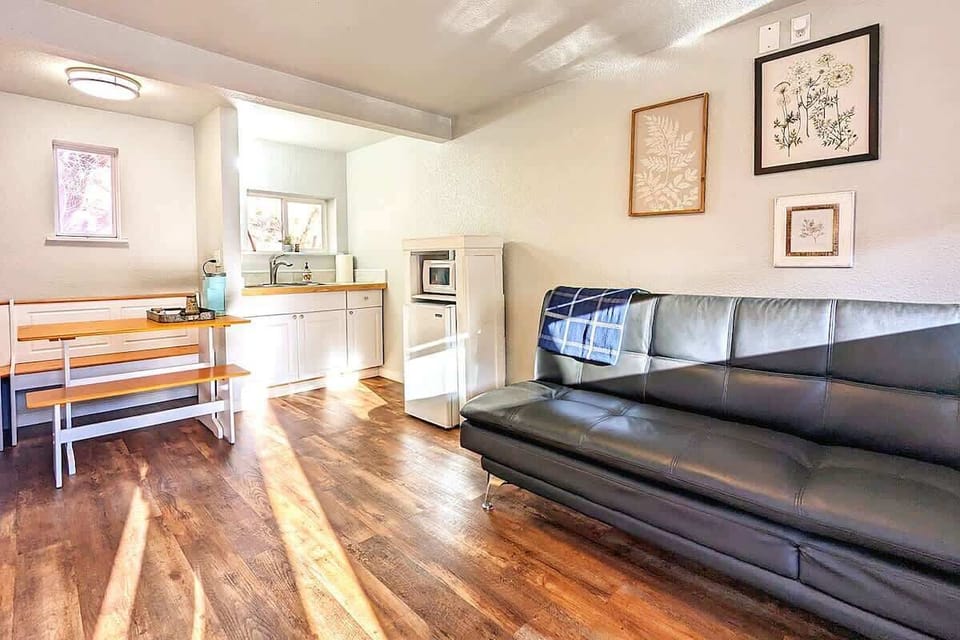 A second angle showing the sofa, dining nook, and kitchenette layout for guest confidence.
