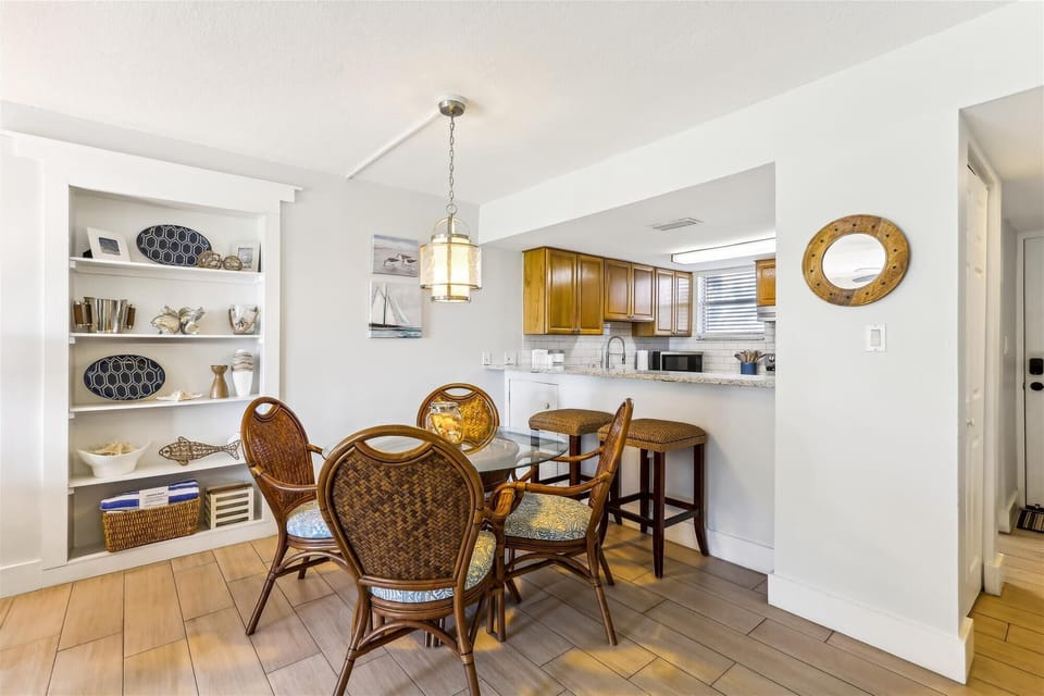 - Gather around the coastal inspired dining table with rattan chairs for meals or game nights
- Open layout connects smoothly with the kitchen and living area for easy flow
- Built in shelving offers decorative beachy touches throughout