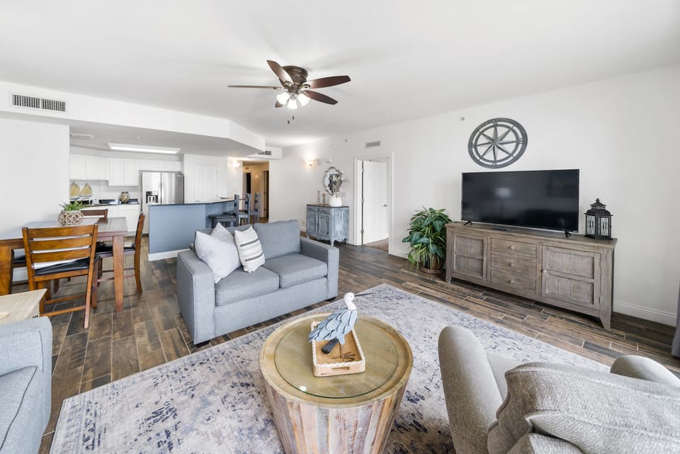 Sink into plush sofas in your airy living space, where coastal charm meets modern comfort beneath soaring ceilings.