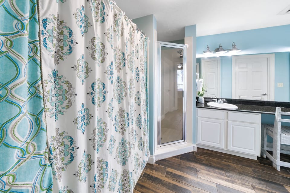 Step into your serene bathroom sanctuary with soothing blue walls and elegant white cabinetry, where your private retreat awaits.