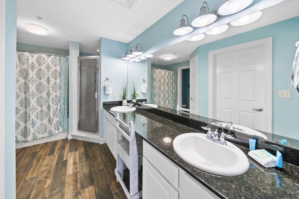 Refresh in your spacious bathroom featuring dual sinks, granite counters, and a luxurious glass shower—perfect for getting ready together.