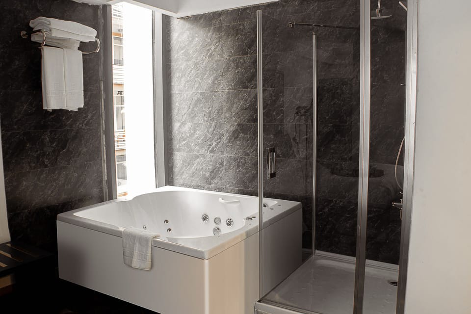Junior Suite | Bathroom | Shower, rainfall showerhead, hair dryer, slippers