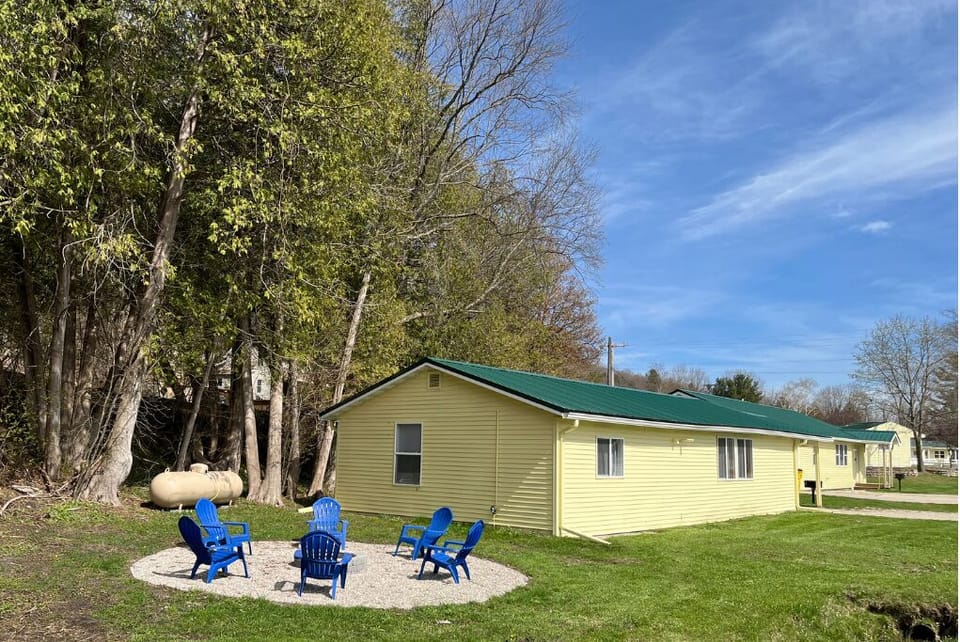 Private firepit with adirondack chairs to the side of the cabin.
