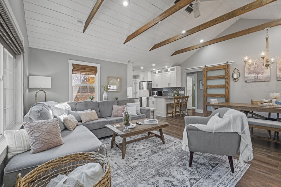 Stylish living room with seamless flow into the dining area, offering plenty of space to unwind during your stay in the quiet neighborhood of Mission, Kansas.