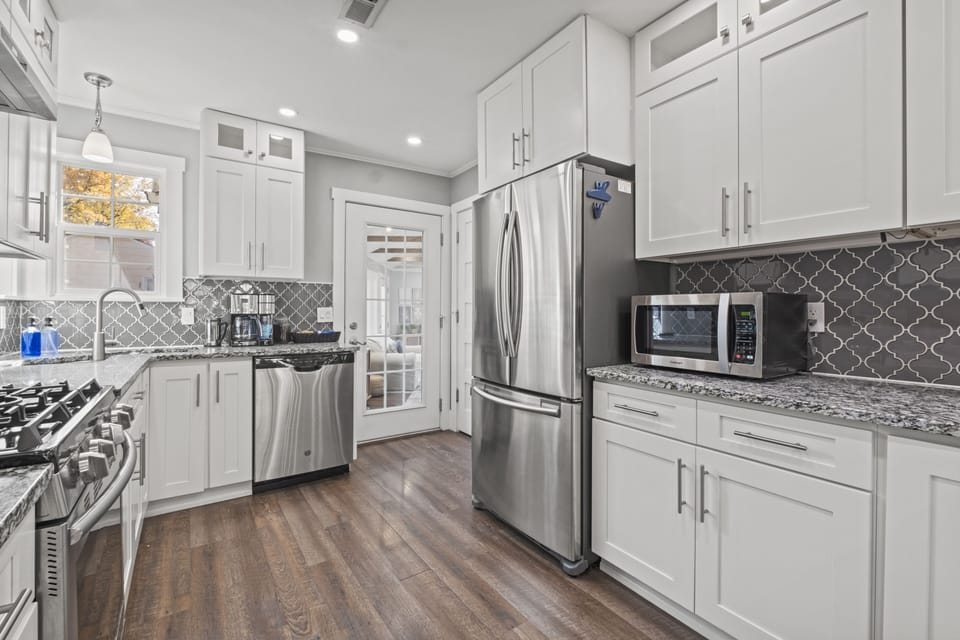Bright, fully equipped kitchen with stainless steel appliances, white cabinetry, and plenty of counter space for cooking at home in Mission, KS.