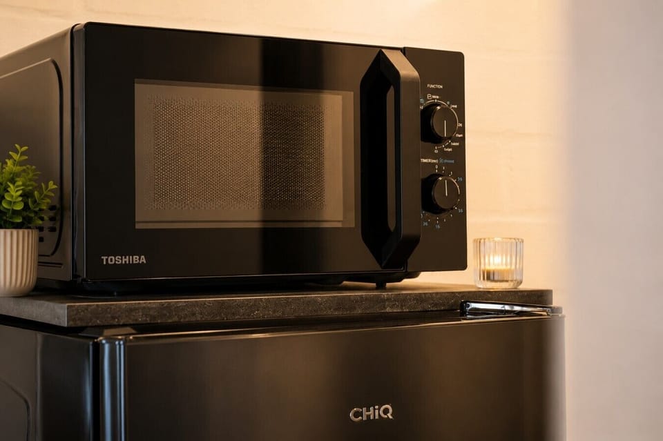The kitchenette includes a microwave and refrigerator, providing everything you need for quick meals and everyday convenience.