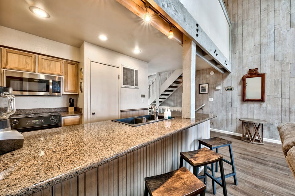 Step into your rustic-modern retreat where granite countertops and exposed beams create the perfect space for cooking memorable meals together.