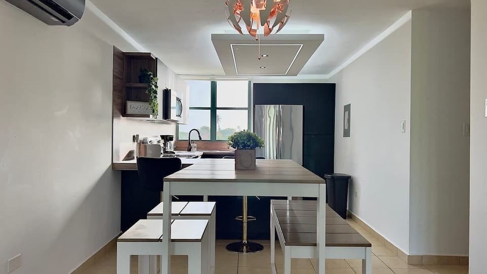Dinning area is conveniently adjacent to the kitchen and offers sitting space for 6 guests in the dinning table and kitchen stools.