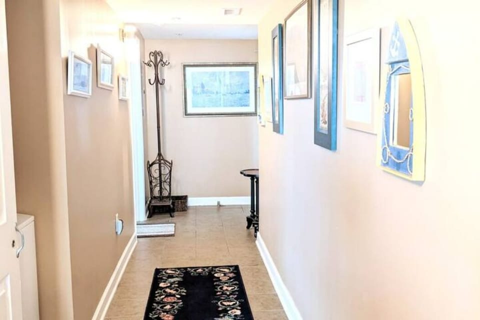 Enter into a bright hall with beachy decor. You’ll find the W&D closet here