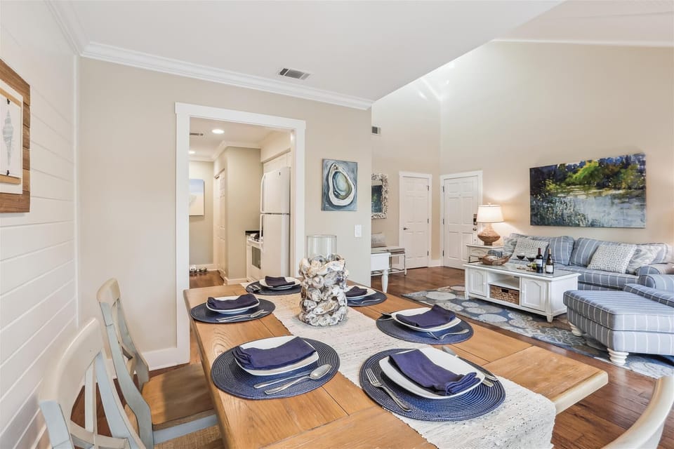 The dining area features a farmhouse table, adorned with ship wall planks and tasteful nautical decor, creating a cozy setting for meals